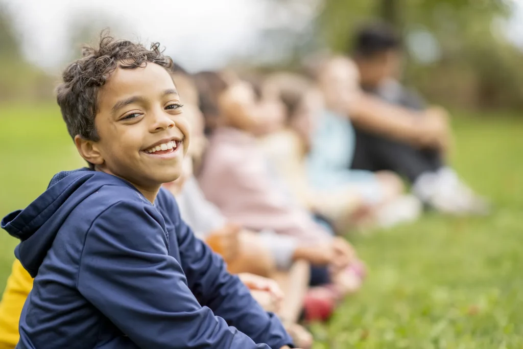 Young Boy Sitting with Friends